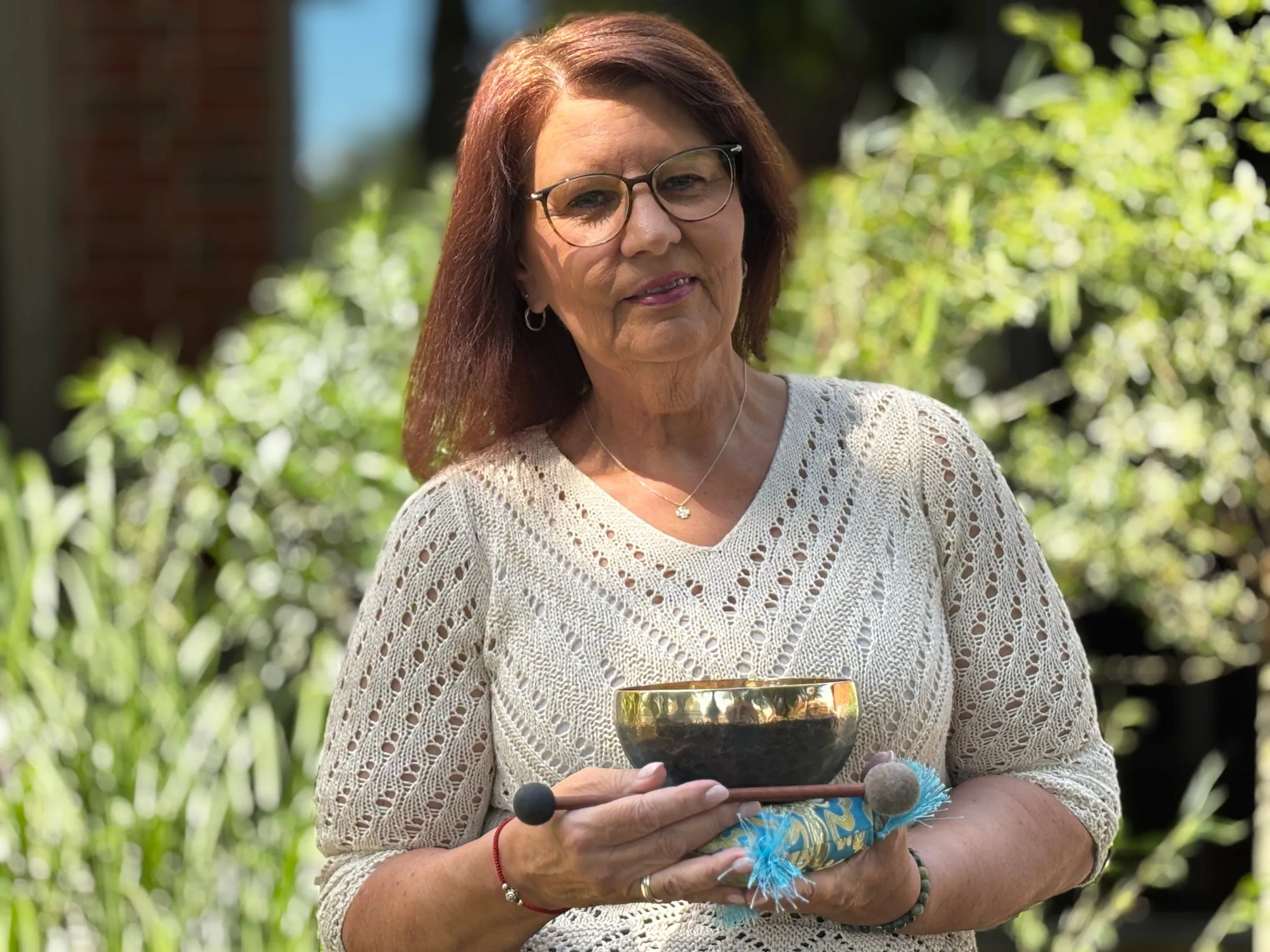 Annette Pitcher mit einer Klangschale in den Händen, sie lächelt freundlich